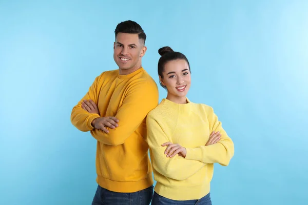 Pareja Feliz Vistiendo Suéteres Cálidos Amarillos Sobre Fondo Azul Claro — Foto de Stock