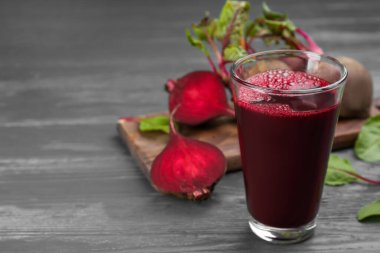 Gri ahşap masada taze pancar suyu ve çiğ sebze. Metin için boşluk