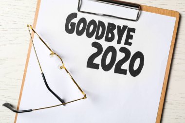 Cümleli pano Elveda 2020 ve gözlükler beyaz ahşap masa, düz yatıyordu