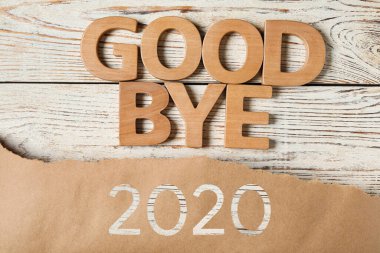 Beyaz ahşap masada 2020 'ye güle güle cümlesiyle bezenmiş düz bir kompozisyon