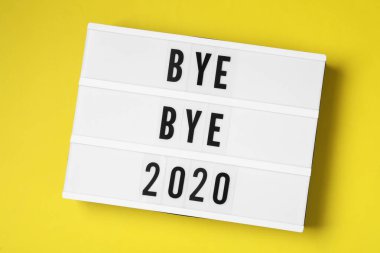 Üzerinde metin olan ışık kutusu. Güle güle 2020 Sarı arka plan, üst görünüm.
