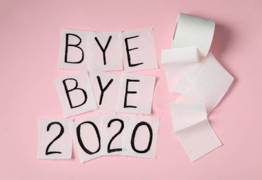 Tuvalet kağıdında mesaj var. Güle güle 2020 pembe arka planda, düz yerde.