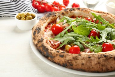 Etli lezzetli pizza ve roka beyaz masada, yakın plan.