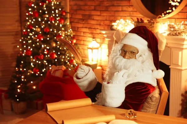 Weihnachtsmann Mit Wunschzettel Bei Tisch Drinnen — Stockfoto