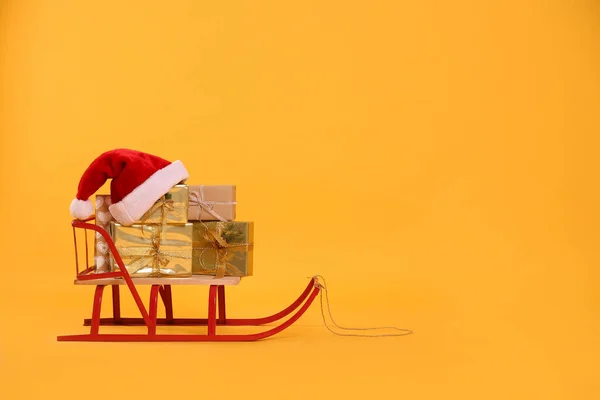 Hediye Kutularıyla Kızak Sarı Arka Planda Noel Baba Şapkası Metin — Stok fotoğraf