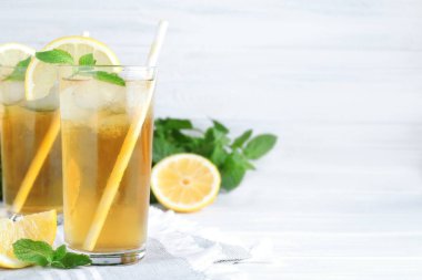 Beyaz ahşap masada limonlu ve naneli lezzetli buzlu çay. Metin için boşluk