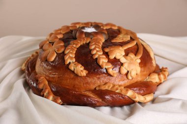 Korovai, gri arkaplana karşı masa örtüsü üzerinde, yakın plan. Ukrayna ekmek ve tuz karşılama geleneği