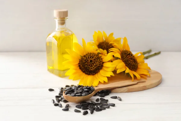 Sonnenblumen Eine Flasche Und Samen Auf Einem Weißen Holztisch — Stockfoto