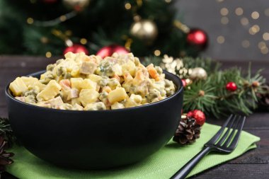 Taze Rus salatası Olivier siyah kasede masada, yakın plan.