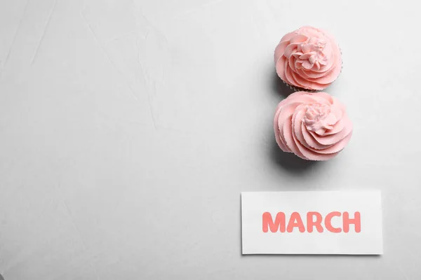3月8日カップケーキとライトグレーの背景 フラットレイアウト上のテキストのためのスペースとグリーティングカードのデザイン 国際女性デー — ストック写真