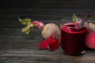 Koyu ahşap masada taze pancar suyu ve çiğ sebze. Metin için boşluk