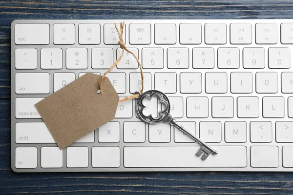 Schlüssel Mit Leerem Anhänger Und Computertastatur Auf Blauem Holztisch Draufsicht — Stockfoto