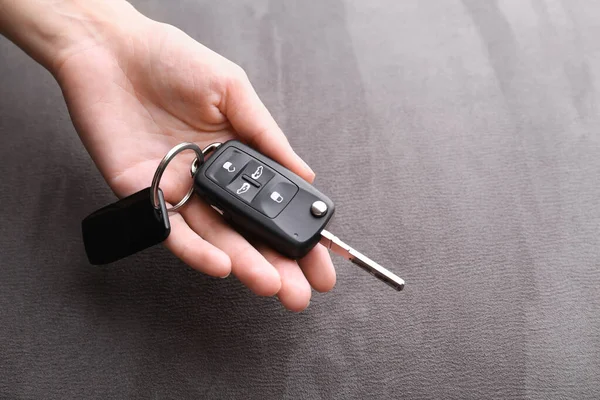 Mujer Sosteniendo Tecla Giro Del Coche Sobre Fondo Gris Primer —  Fotos de Stock