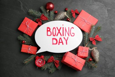 Düz kompozisyon, Noel tabelası ve siyah masa üzerinde Noel hediyeleri vardı.