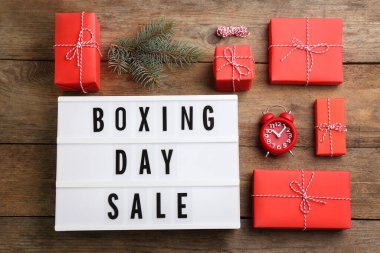 Düz kompozisyon, Noel indirimi tabelası ve ahşap masada Noel hediyeleri vardı.