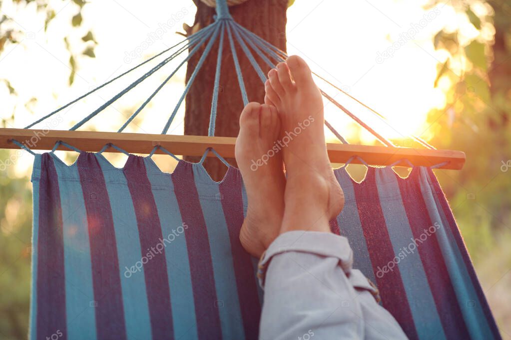 Man resting in comfortable hammock at green garden, closeup