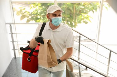 Koruyucu maskeli ve eldivenli bir kurye. Coronavirus karantinası sırasında restoran teslimat servisi