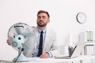 İş yerindeki havalandırmadan hava akışının keyfini çıkaran adam