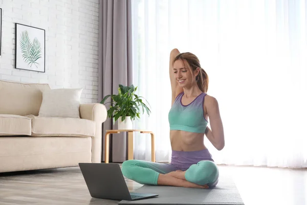 在家里通过笔记本电脑上在线视频课的妇女 大肠病毒大流行期间的远程瑜伽课程 — 图库照片