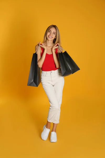 Glückliche Junge Frau Mit Einkaufstaschen Auf Gelbem Hintergrund Black Friday — Stockfoto