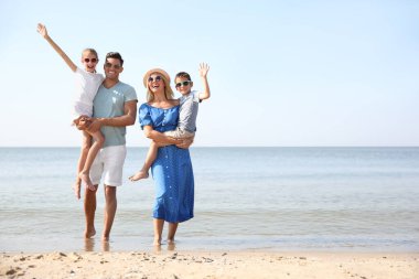 Mutlu aile güneşli yaz gününde sahilde