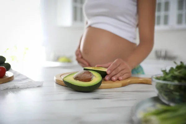 Jovem Grávida Com Abacate Mesa Cozinha Close Cuidar Saúde Bebê — Fotografia de Stock