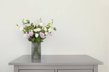 Bir buket güzel Eustoma çiçeği açık duvarın yanındaki çekmecelerin üzerinde. Metin için boşluk