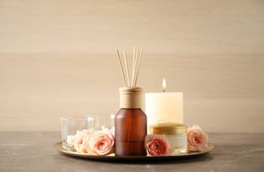 Gri masadaki aroma yağı ve güllerle spa kompozisyonu