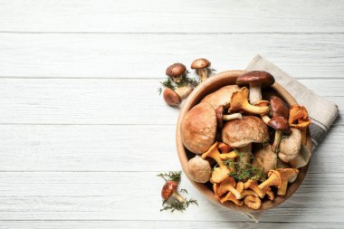 Beyaz ahşap masa üzerinde farklı taze mantarlar, düz yatış. Metin için boşluk