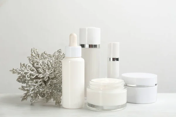 Beautiful composition with different cosmetic products on white table. Winter care