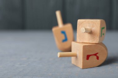 Hanuka geleneklerine göre Gimel ve O harfleri gri ahşap masada, yakın plan. Metin için boşluk