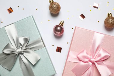 Güzel hediye kutuları, Noel baloları ve beyaz arka planda konfeti, düz yatış