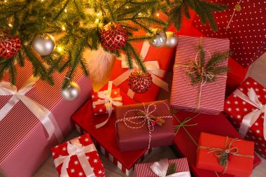 Noel ağacının yanında yere yığılmış hediye kutuları.