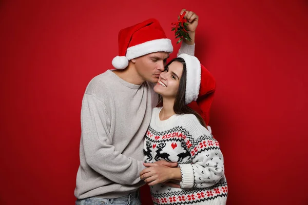 Casal Feliz Sob Bando Visco Fundo Vermelho — Fotografia de Stock