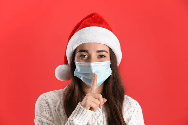 Mulher Bonita Vestindo Chapéu Papai Noel Máscara Médica Fundo Vermelho — Fotografia de Stock