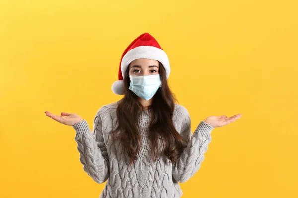 Mulher Bonita Vestindo Chapéu Papai Noel Máscara Médica Fundo Amarelo — Fotografia de Stock