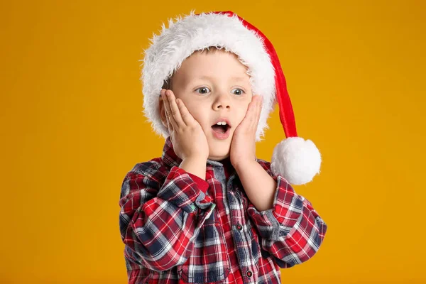 黄色の背景にサンタの帽子のかわいい子供 クリスマスのお祝い — ストック写真