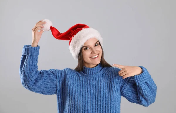 Noel Baba Şapkalı Güzel Kadın Gri Arka Planda Mavi Süveter — Stok fotoğraf
