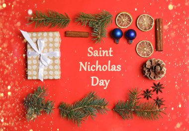 Aziz Nicholas Günü. Kırmızı arka planda Noel dekoru olan düz konum