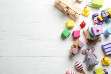 Beyaz ahşap arka planda, düz zeminde farklı oyuncaklar. Metin için boşluk