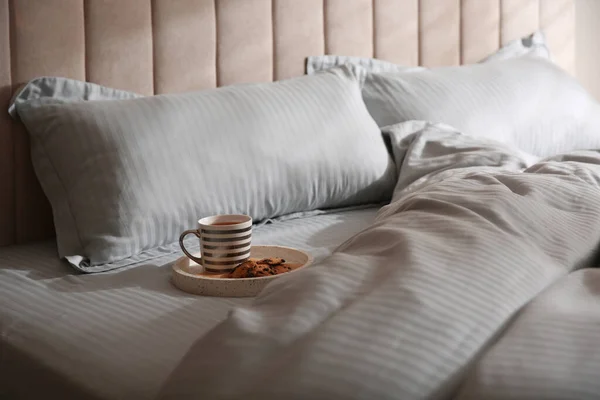 Tray with breakfast and soft blanket on bed