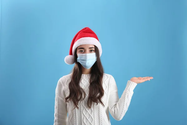 Vacker Kvinna Bär Santa Claus Hatt Och Medicinsk Mask Ljusblå — Stockfoto
