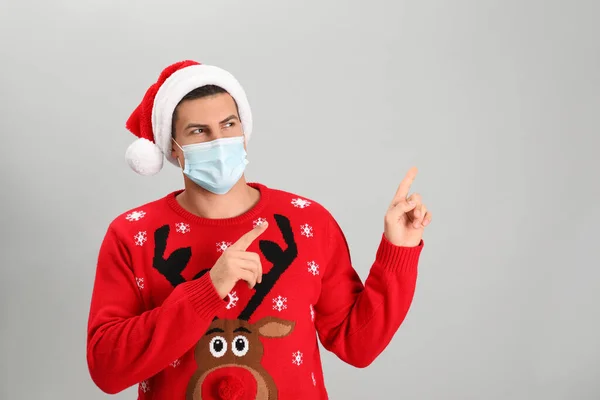Man Bär Santa Hatt Och Medicinsk Mask Grå Bakgrund — Stockfoto