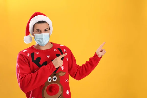 Man Bär Santa Hatt Och Medicinsk Mask Gul Bakgrund Utrymme — Stockfoto