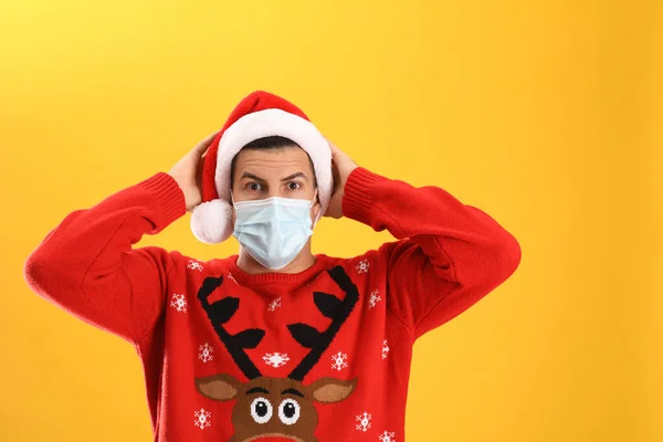 Homem Surpreso Usando Chapéu Papai Noel Máscara Médica Fundo Amarelo — Fotografia de Stock