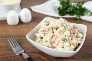 Geleneksel Rus salatası Olivier ahşap masada servis edilir.