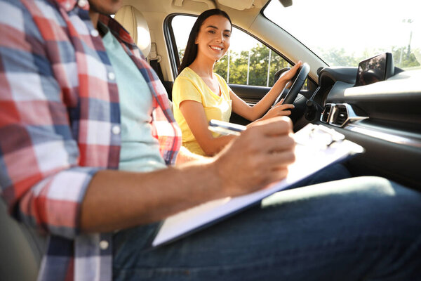 Young woman in car with instructor. Driving school