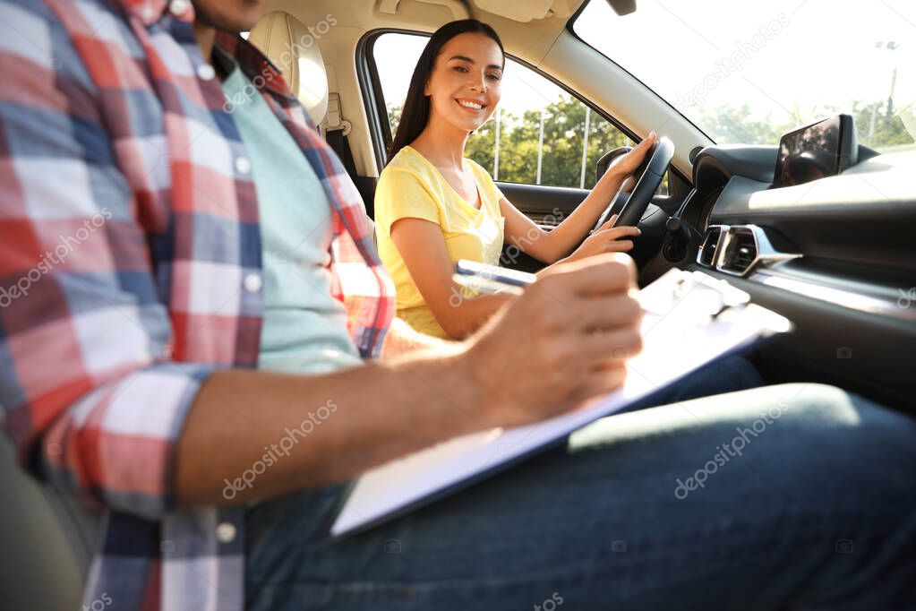 Young woman in car with instructor. Driving school