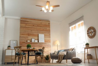 Modern tavan vantilatörü ve düşük açılı manzaralı şık bir oturma odası.