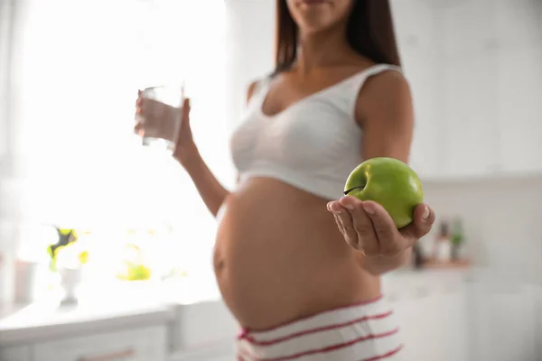 Молодая Беременная Женщина Держит Стакан Воды Яблоко Кухне Сосредоточиться Руку — стоковое фото